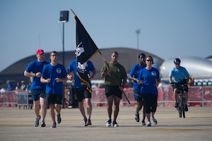 Marine Corps (Ret.) GySgt Ryan Rivera and members of Air Force Sergeants Association Chapter 102, run the POW/MIA flag to the show center to mark the start of the 2015 Joint Base Andrews Airshow, Sept. 18. (U.S. Air Force photo/Staff Sgt. Nichelle Anderson/Released)