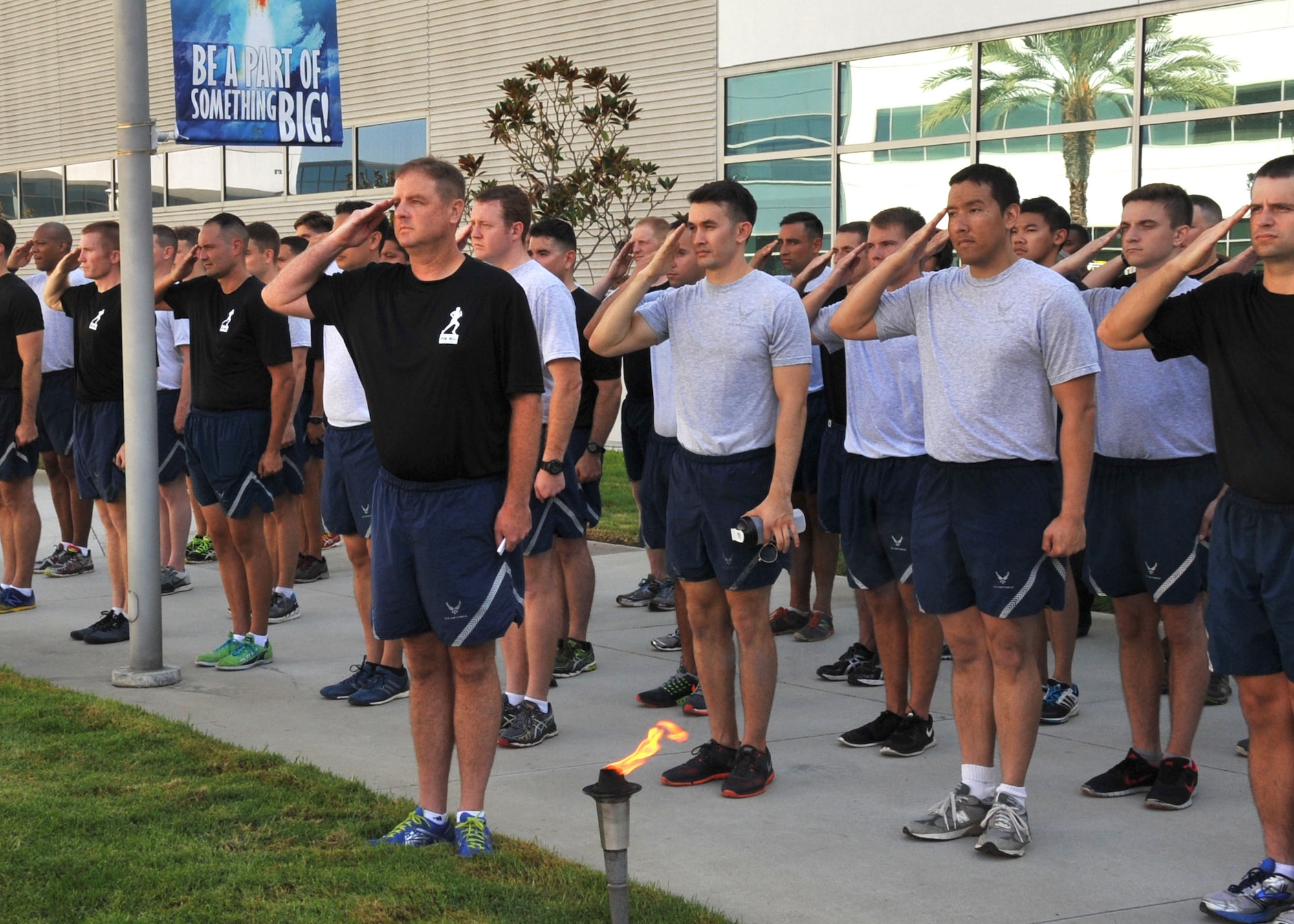 The POW/MIA torch relay team renders honors during the National Anthem at the start of the National POW/MIA Recognition Day ceremony at the Space and Missile Systems Center's Schriever Space Complex flagpole at Los Angeles Air Force Base in El Segundo, Calif. (U.S. Air Force photo/Sarah Corrice)