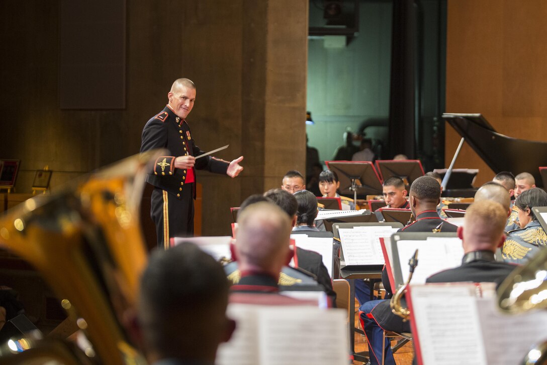 U.S. Marine Chief Warrant Officer 3 Joshua A. Stone conducts a combined band composed of the III Marine Expeditionary Force Band and the Japan Ground Self-Defense Force’s 15th Brigade Band, during the 20th Annual Combined Band Concert, at Okinawa Civic Hall, in Okinawa City, Okinawa, Japan, Sept. 19, 2015. The concert celebrated the long-standing relationship between the Marine and JGSDF musical ensembles, affording them the opportunity to once again combine forces and musically stimulate an audience.