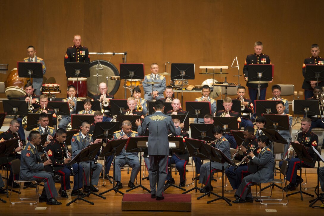 A combined band made up of the III Marine Expeditionary Force Band and the Japan Ground Self-Defense Force’s 15th Brigade Band, plays during the 20th Annual Combined Band Concert, at Okinawa Civic Hall, in Okinawa City, Okinawa, Japan, Sept. 19, 2015. The concert celebrated the long-standing relationship between the Marine and JGSDF musical ensembles, affording them the opportunity to once again combine forces and musically stimulate an audience.