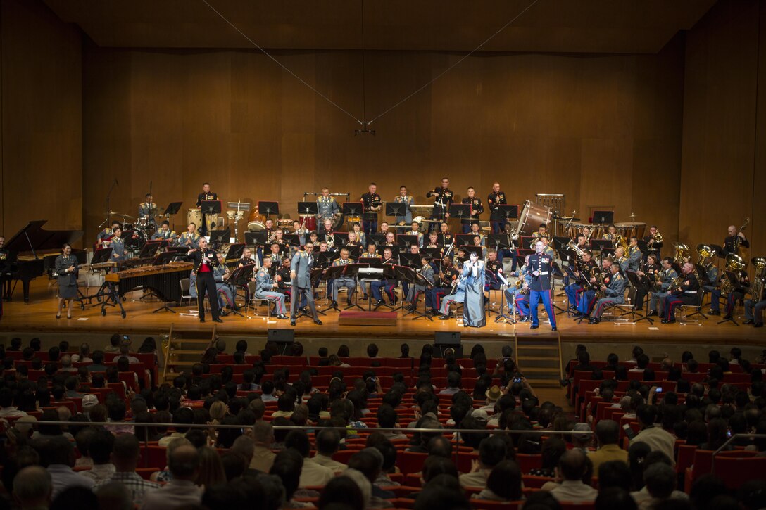 The III Marine Expeditionary Force Band and the 15th Brigade Band, Japan Ground Self-Defense Force, engage the crowd during the 20th Annual Combined Band Concert, at Okinawa Civic Hall, in Okinawa City, Okinawa, Japan, Sept. 19, 2015. The concert celebrated the long-standing relationship between the Marine and JGSDF musical ensembles, affording them the opportunity to once again combine forces and musically stimulate an audience.
