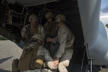 U.S. Marines assigned to Marine Corps Security Force Regiment, Fleet Antiterrorism Security Team (FAST) Company, Fifth Platoon, load simulated casualties into an MV-22B Osprey assigned to Marine Medium Tiltrotor Squadron (VMM) 365, during a casualty evacuation (CASEVAC) drill near Marine Corps Air Station New River, N.C., Sep. 2, 2015. VMM-365 supported FAST Marines by providing a means of quickly evacuating simulated casualties during a CASEVAC drill.