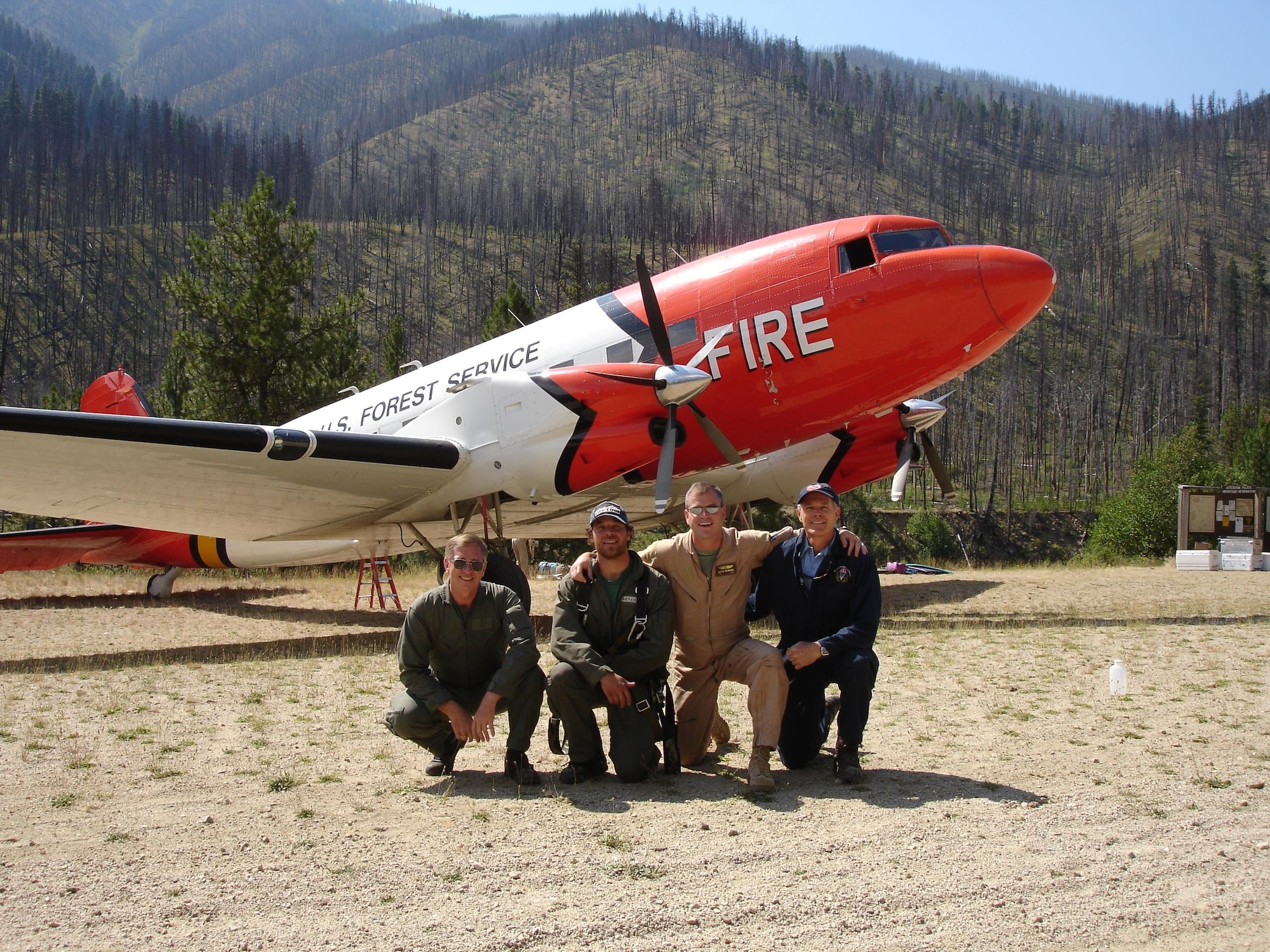 Col. Paul "Buster" Delmonte, the Emergency Preparedness Liaison Officer for Utah, is a lead plane pilot for the U.S. Forest Service as a civilian. In this capacity, he acts as a sort of forward operator, directing other fire fighting aircraft where to drop fire retardant. Delmonte is pictured here in a tan flight suit in front of one of his aircraft, a DC-3.