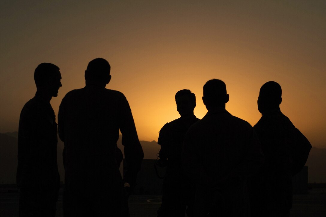 U.S. airmen talk during an EC-130H Compass Call aircraft final mission meeting on the flight line at Bagram Airfield, Afghanistan, Sept. 6, 2015. U.S. Air Force photo by Tech. Sgt. Joseph Swafford