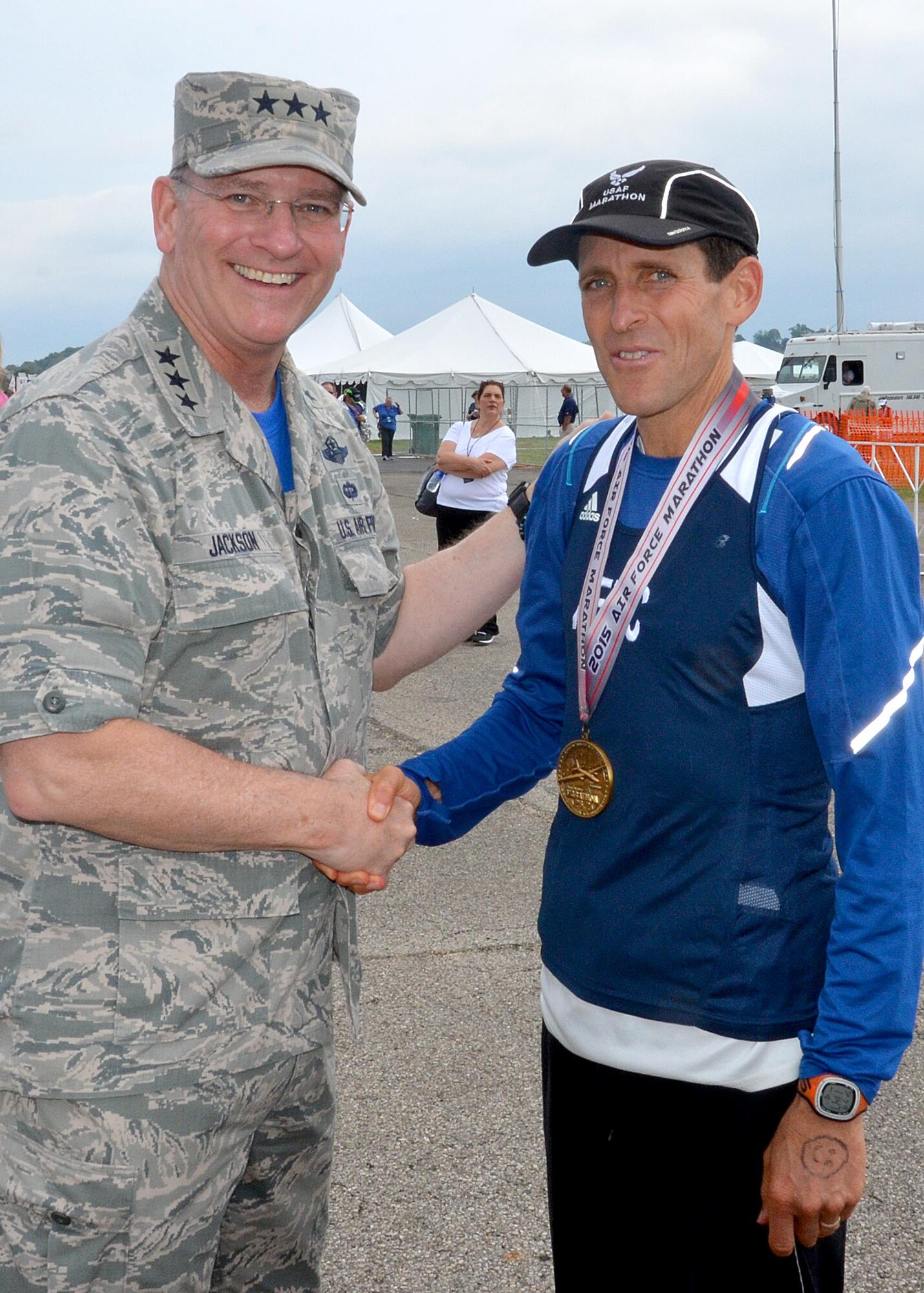 Lt. Col. Mark Cucuzzella, an individual mobilization augmentee is greeted by Lt. Gen. James Jackson, commander, Air Force Reserve Command, after crossing the finish line at the 19th Annual Air Force Marathon Sept. 19, 2015. Cucuzzella, a member of the Air Force Reserve Command MAJCOM Challenge Team completed the full marathon in 2:57:59. He placed first in his division. The team consisted of traditional reservists, air reserve technicians, individual mobilization augmentees and Air Guard Reserve members. The MAJCOM challenge included six Airmen participating in the half marathon and four in the full marathon. (U.S. Air Force photo /Lt. Col. Cynthia Harris) 