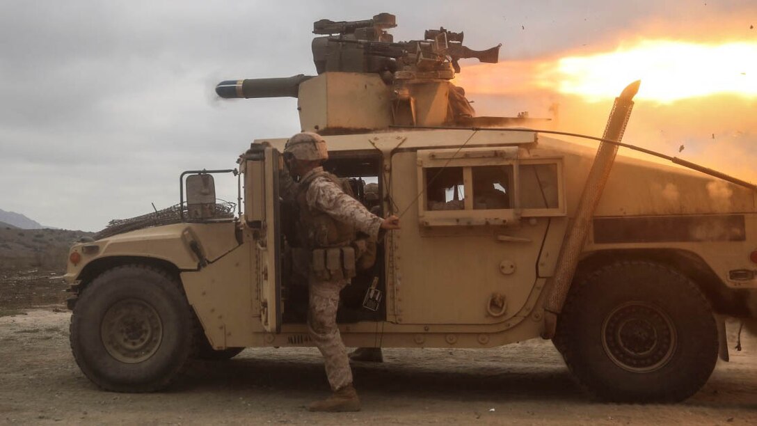 A U.S. Marine with the Combined Anti-Armor Team (CAAT) within Battalion Landing Team (BLT) 2/1, the ground combat element for the 13th Marine Expeditionary Unit, pulls a radio antenna clear of  the backblast of a Tube-launched, Optically-tracked, Wire-guided (TOW) missile during training on Aug. 21, 2015. The CAAT, composed of heavy machine gunners and anti-tank missilemen, is used to combat hardened targets as well as provide security. 