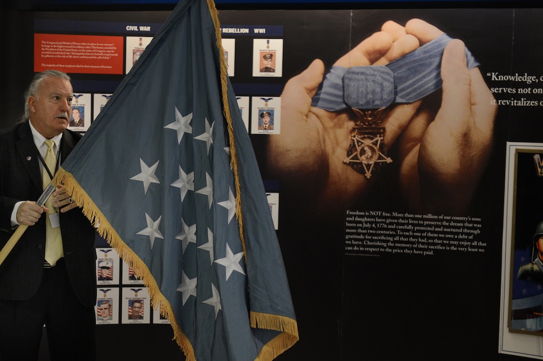 Richard Cochran Jr., chief of staff of the Hispanic Medal of Honor Society, carries the Medal of Honor Flag during the Hispanic Medal of Honor ribbon-cutting ceremony for a new display at the Pentagon, Sept. 18, 2015. The temporary display honors Hispanic Medal of Honor recipients from the Civil War to the present. The society also is showcasing exhibits honoring Hispanic Medal of Honor recipients in the Pentagon and throughout the region, paying tribute to Hispanic heritage and service. National Hispanic Heritage Month runs from Sept. 15 through Oct. 15, 2015. DoD photo by Marvin Lynchard