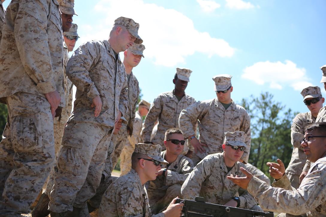 Marines from Battery M, 3rd Battalion, 14th Marine Regiment, 4th Marine Division gather together as a class is given covering the fundamentals, functions and safety procedures of crew-served weapons at Pelham Range in Anniston, Alabama, on Sept. 19, 2015. The Marines applied all of their knowledge and increased their proficiency in firing the M249 SAW, the M240 and the M250.