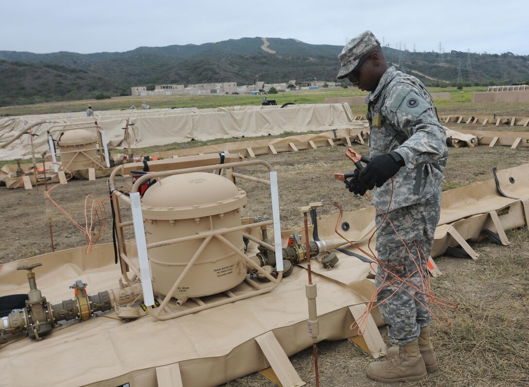 Quartermaster soldiers set up a fuel station in Camp Pendleton, Calif., as part of Quartermaster Liquid Logistics Exercise 2014. QLLEX is a joint forces exercise that 64 units at eight locations across the continental U.S. will deliver more than 3.25 million gallons of petroleum and produce 479,000 gallons of water, designed to challenge and develop the battalion's staff military decision making skills. (U.S. Army photo by Sgt. Alejandro C. Canizales/Released)