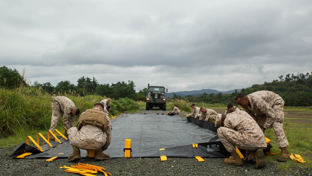 Marines with Marine Wing Support Squadron 171, stationed aboard Marine Corps Air Station Iwakuni, Japan, lay down a berm to catch any fuel that could possibly leak out of the MK970 semi-trailer refueler at Sekiyama Training Area, Japan, Sept. 8, 2015, in support of Exercise Forest Light 16-1. MWSS-171 is supporting Marine Heavy Helicopter Squadron 462 and 1st Battalion 2nd Marines during this exercise using their communications, motor transport and refueling capabilities.