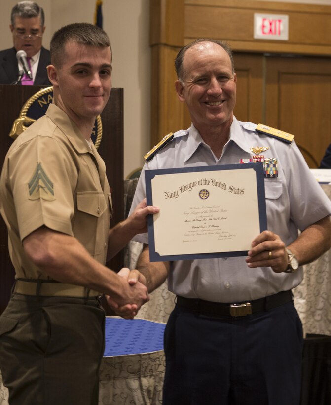 Cpl. Daaron T. Horning, a precision measurement equipment technician with Marine Air Group 49, 4th Marine Aircraft Wing, receives the MAG-49 Award from Rear Admiral David Callahan, commander of Eight Coast Guard District, during Military Appreciation Day 2015 in New Orleans, Sept. 18, 2015. The event was hosted by the Greater New Orleans Council of the Navy League of the United States to recognize the contributions of service members stationed in the New Orleans area. (U.S. Marine Corps photo by Cpl. Ian Leones/Released)