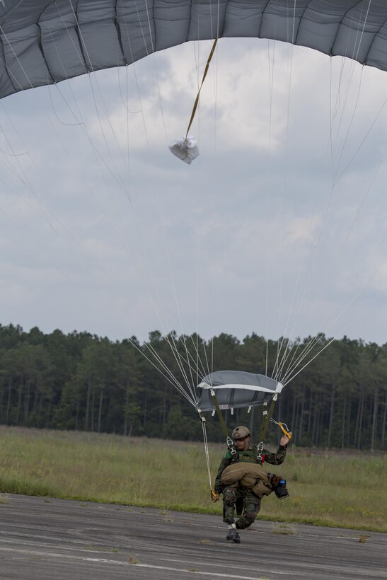 A Marine Raider with U.S. Marine Corps Forces, Special Operations Command, touches down after parachuting with a Multi-Purpose Canine at Marine Corps Base Camp Lejeune, N.C., Sept. 10, 2015. As MARSOC continues to demonstrate their versatile capabilities, MPC handlers with the command are preparing their canines to maneuver in new areas of operation.