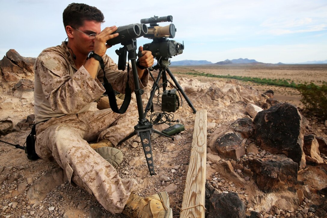 Sergeant Andrew Dimauro, the communications chief with Support Assault Arms Liaison Team D, 1st Brigade Platoon, 1st Air Naval Gunfire Liaison Company, I Marine Expeditionary Force, observes targets during an integrated close air support training evolution with units from the U.S. Air Force, aboard Air Force Base Gila Bend, Ariz., Aug. 23-28, 2015. The training improved interoperability between the Marine Joint Terminal Attack Controllers and supporting Air Force units and helped to refined CAS techniques and procedures.