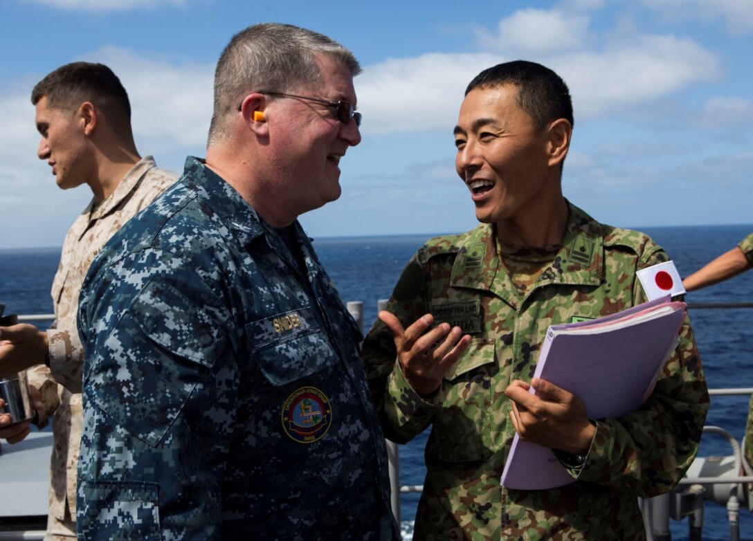 U.S Navy Captain Lance Snider, speaks with Maj. Toshinori Ushida, Japanese Ground Self Defense-Force tactics instructor, aboard the amphibious assault ship USS Boxer (LHD 4) during Exercise Dawn Blitz 2015, Sept. 4, 2015. Dawn Blitz is a scenario-driven exercise designed to train the U.S. Navy and Marine Corps in amphibious operations while building U.S. and coalition interoperability. (U.S. Marine Corps photo by Lance Cpl. April L. Price/Released)