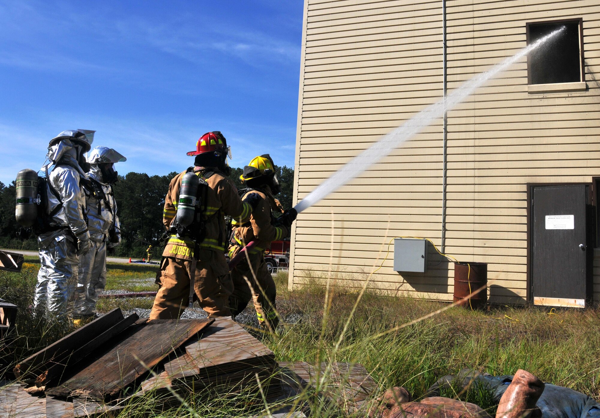 A team of Dobbins firefighters works to put out a simulated fire on the second floor of the structure-fire simulator on Sept. 15, 2015 at Dobbins Air Reserve Base, Ga. Smoke machines and flashing red and yellow lights are used in the structure to simulate a fire. (U.S. Air Force photo/Senior Airman Andrew Park)