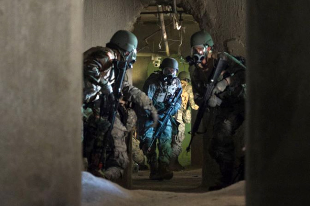 Participants in the Air Force Research Laboratory's 2015 Tech Warrior exercise leave a tunnel after the release of a smoke grenade simulating mustard gas during a training scenario at the National Center for Medical Readiness in Fairborn, Ohio, Sept. 15, 2015. During the exercise, participants learned a variety of skills such as base defense, self-aid and buddy care, and tactical vehicle driving and land navigation. U.S. Air Force photo by Wesley Farnsworth