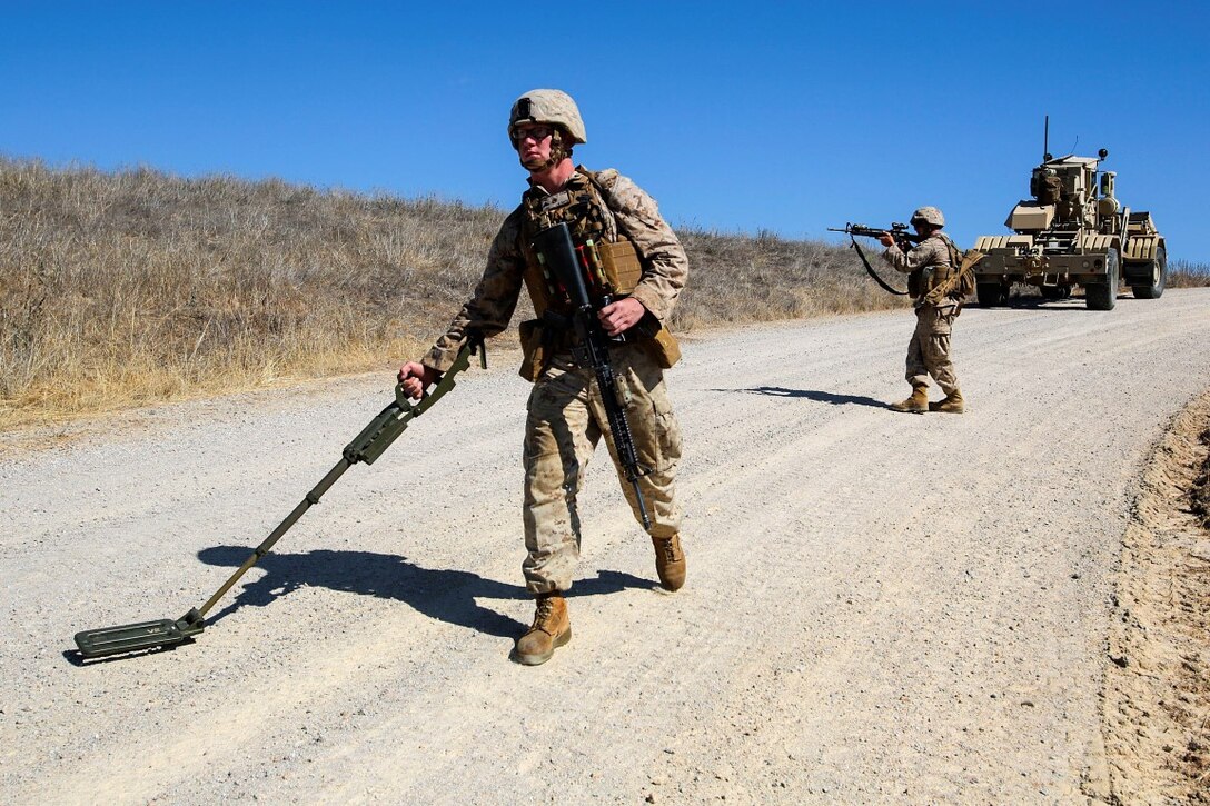 Lance Cpl. Alec Smith, a combat engineer with Mobility Assault Company, 1st Combat Engineer Battalion, 1st Marine Division,  and an Elcho, Wis., native, sweeps the road for simulated Improvised Explosive Devices during Exercise Pioneer Express aboard Camp Roberts, Calif., Sept. 3, 2014. The exercise ensures that Marines and Sailors remain effective in increasingly complex environments through challenging training and detailed evaluation. (U.S. Marine Corps photo by Lance Cpl. Caitlin Bevel)