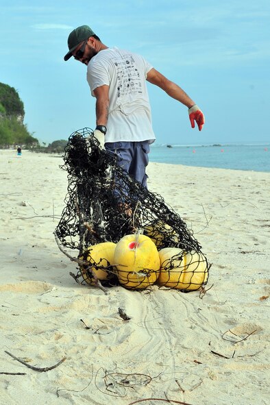 Patrick Mantanona, University of Guam Sea Turtle Monitoring, Protection and Educational Outreach on Guam field technician, removes trash from Tarague Beach at Andersen Air Force Base, Guam, during Guam’s 20th International Coastal Cleanup Sept. 19, 2015. More than 140 volunteers collected 22 bags of trash and 10 bags of recyclables from the base beach during the annual event. (U.S. Air Force photo by Tech. Sgt. Melissa B. White/Released)