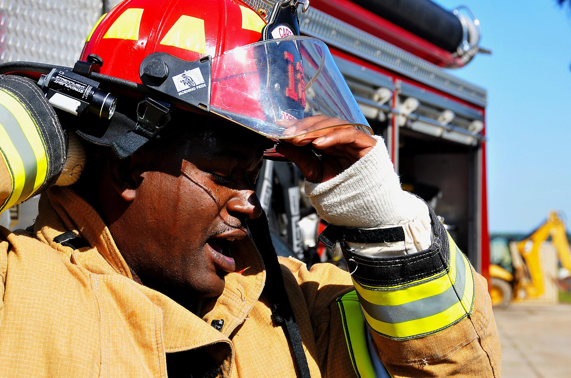 A Dobbins firefighter removes his helmet after the completion of the firefighting exercise at Dobbins Air Reserve Base, Ga. on Sept. 15, 2015. Smoke machines and flashing red and yellow lights are used in the structure to simulate a fire. The team was responsible for retrieving the training dummy from the window on the second floor. (U.S. Air Force photo/Senior Airman Andrew Park) 