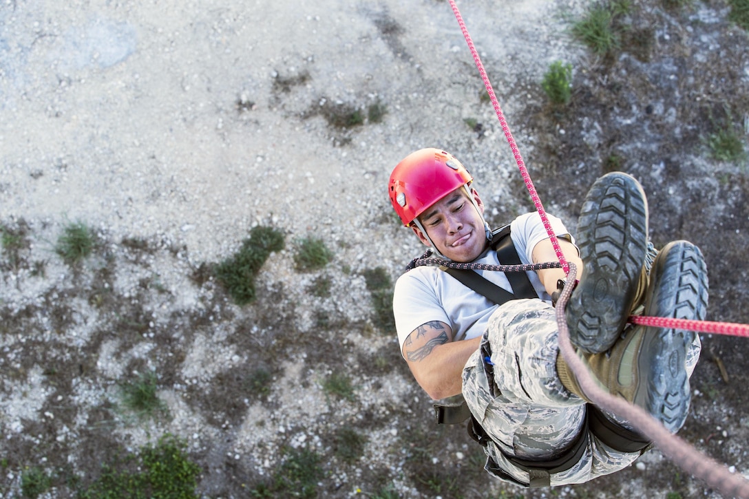 Air Force Senior Airman Christian Torres performs an inversion technique during a rappelling demonstration as part of the 2015 Battle of the Badges competition for first responders on Joint Base San Antonio, Sept. 12, 2015. Torres is a firefighter with the 502nd Civil Engineer Squadron. U.S. Air Force photo by Senior Airman Alexandria Slade
