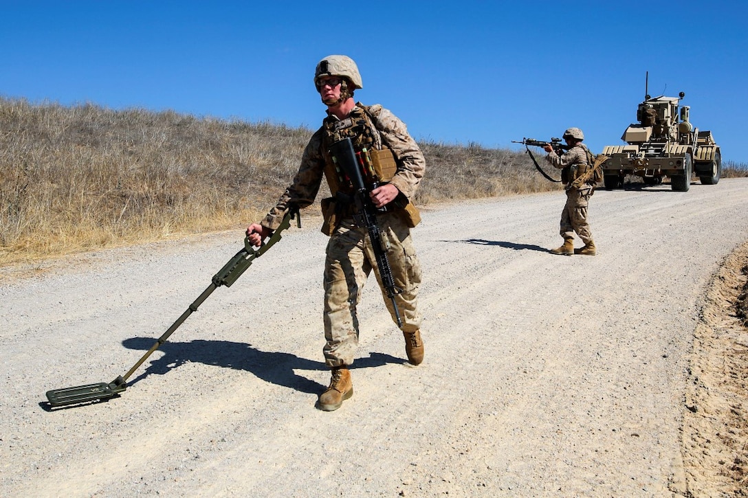 Lance Cpl. Alec Smith, a combat engineer with Mobility Assault Company, 1st Combat Engineer Battalion, 1st Marine Division,  and an Elcho, Wis., native, sweeps the road for simulated Improvised Explosive Devices during Exercise Pioneer Express aboard Camp Roberts, Calif., Sept. 3, 2014. The exercise ensures that Marines and Sailors remain effective in increasingly complex environments through challenging training and detailed evaluation. (U.S. Marine Corps photo by Lance Cpl. Caitlin Bevel)