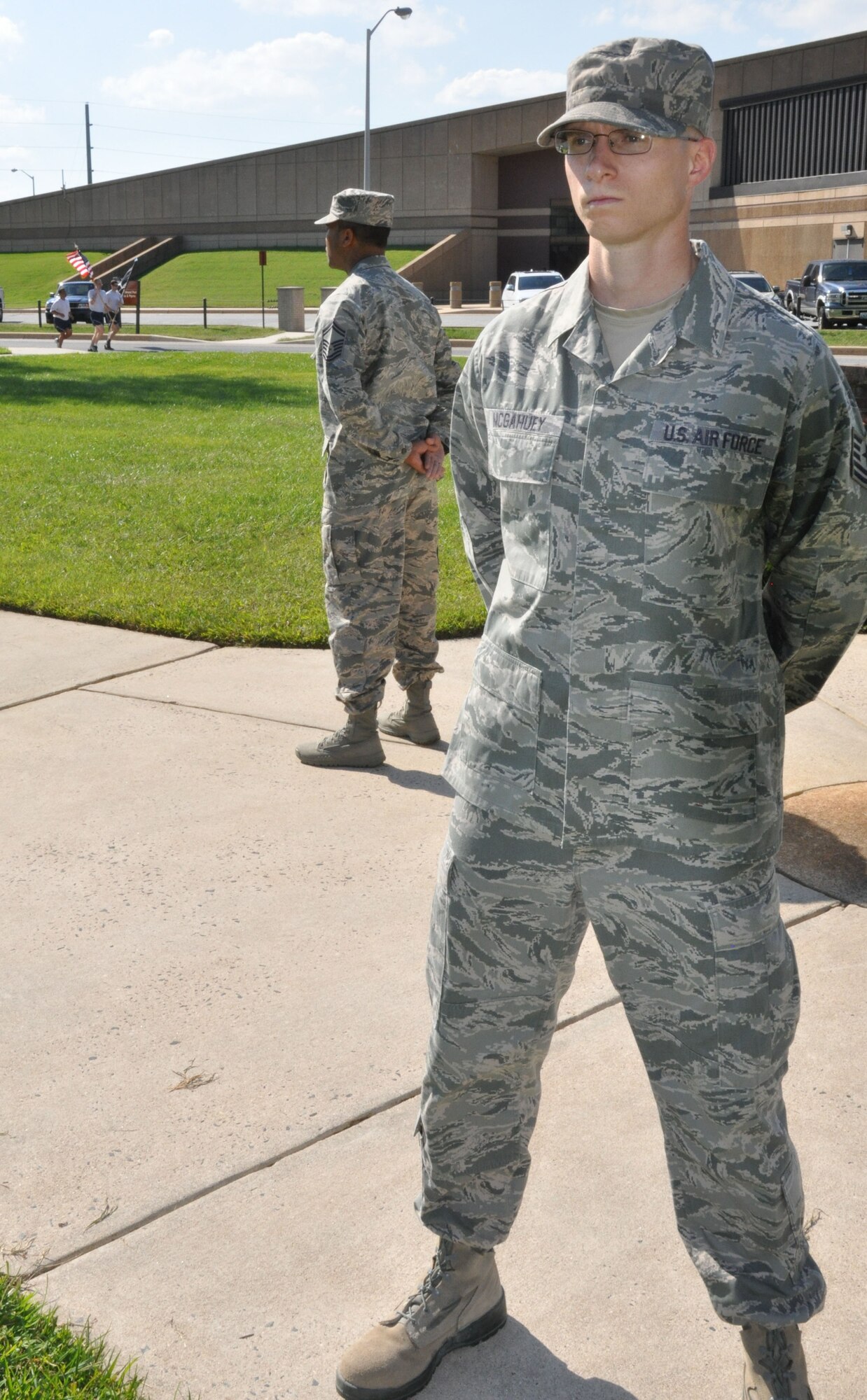 Tech. Sgt. Sean McGahuey (right) and Senior Master Sgt. Anthony Harris, both from the 512th Force Support Squadron, stand in vigil as other members of Team Dover in the background run laps around the base flag pole in observance of  POW/MIA Recognition Day Sept.18, 2015 at Dover Air Force Base, Del. The event's sponsor, The National League of POW/MIA, consists of approximately 1,000 war veterans and relatives of American armed services members who are prisoners of war or missing in action. (U.S. Air Force photo/Staff Sgt. Joe Yanik)