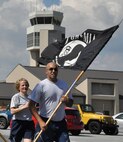 Capt. Jason Lowrey (right) and 1st Lt. Deborah Hautanen, 512th Airlift Wing staff, run laps around the base flag pole carrying the prisoner-of-war flag as part of Team Dover's observance of 2015 POW/MIA Recognition Day September 18, 2015, at Dover Air Force Base, Del. The 18th marks the end of 2015 POW/MIA Recognition Week when Americans from across the country hold local ceremonies remembering past and present American prisoners of war and missing in action. (U.S. Air Force photo/Staff Sgt. Joe Yanik)
