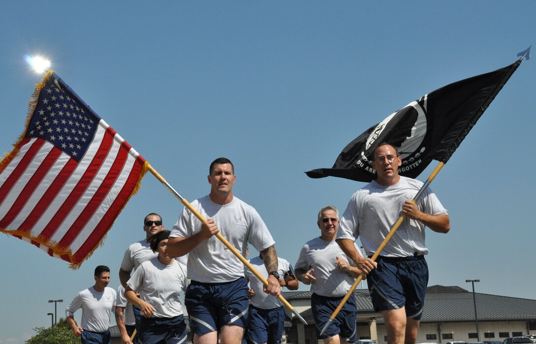 Reservists and active-duty Airmen from Team Dover run a lap around the base flag pole in observance of POW/MIA Recognition Day Sept.18, 2015, at Dover Air Force Base, Del. The 18th marked the last day of 2015 POW/MIA Recognition Week, a time when Americans across the country held local ceremonies to remember the nation's past and present prisoners of war and missing in action, while also highlighting the U.S. government's commitment to account for them. (U.S. Air Force photo/Staff Sgt. Joe Yanik) 