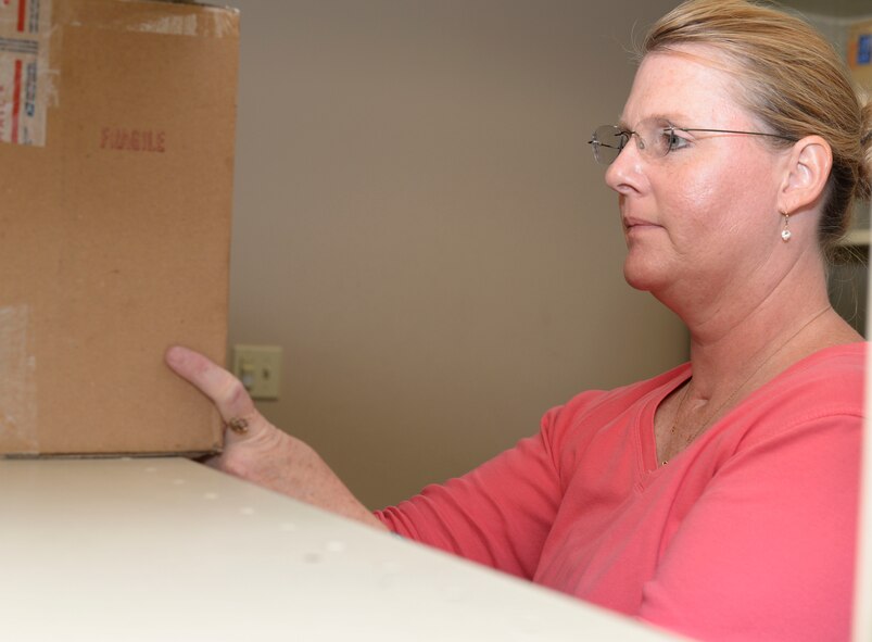 Holly Burcham, 2nd Communications Squadron postal clerk, places a package on a shelf in the holding room at Barksdale Air Force Base, La., Sept. 3, 2015. After storing the packages in the secure room, postal center employees place a package slip in the Airman’s postal box to inform them they have mail. (U.S. Air Force photo/Senior Airman Amanda Morris)