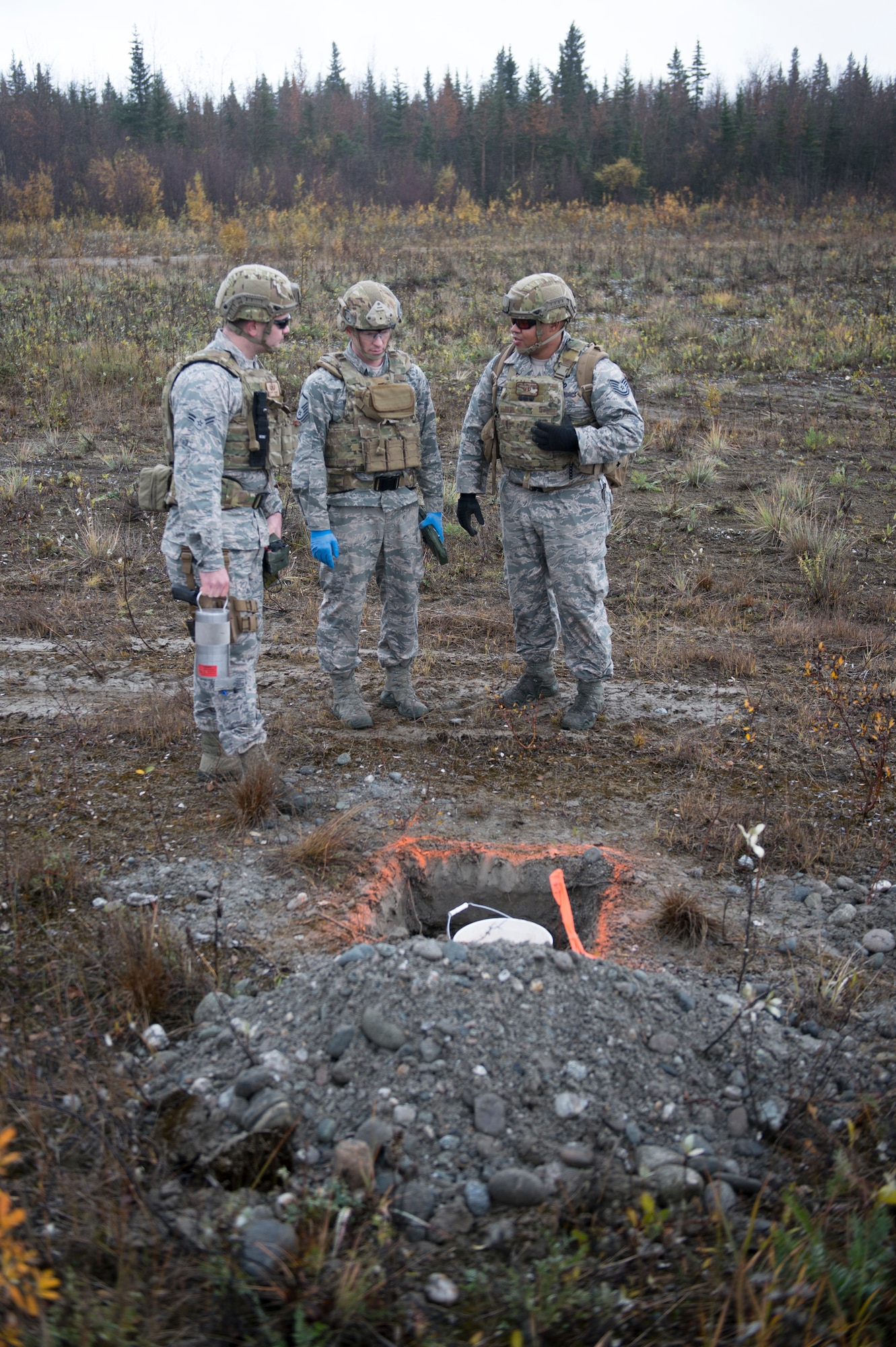 Airman 1st Class Dillon Babb (left), Master Sgt. Harold Horton (center) and Tech. Sgt. Michael Alexander II (right), all Eielson Air Force Base, Alaska, 354th Civil Engineer Squadron explosive ordinance disposal (EOD) technicians, prepare to blow up one of four buckets containing 65 sticks deteriorating dynamite removed from a garage in Delta Junction, Alaska, Sept. 20, 2015. Eielson’s EOD technicians, which form the smallest operational flight in the Air Force, respond around the northern part of the state covering an area of responsibility larger than the state of Texas when local civil authorities call for the mutual aid. (U.S. Air Force photo by Staff Sgt. Shawn Nickel/Released)