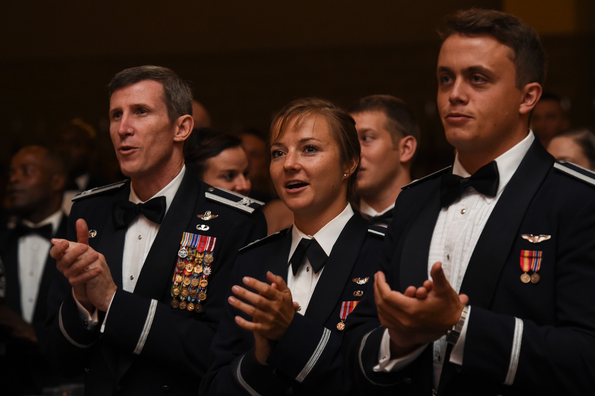 U.S. Air Force Col. Thomas Kunkel, 23d Wing commander, left, Capt. Christy Wise, 71st Rescue Squadron HC-130 pilot, and  1Lt. Timothy Wiser, HH-60G Pave Hawk pilot, sing the Air Force song during the Air Force Ball Sept. 19, 2015, in Valdosta, Ga. Approximately 400 Airmen, family and friends congregated to celebrate 68 years of Air Force heritage. (U.S. Air Force photo by Senior Airman Ceaira Tinsley/Released)