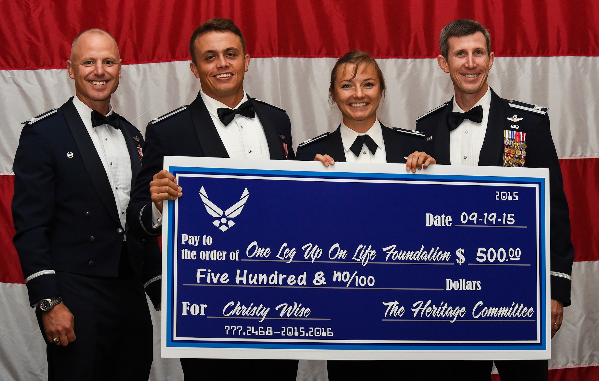 U.S. Air Force Capt. Christy Wise, 71st Rescue Squadron HC-130 pilot, and base leadership pose for a photo at the Air Force Ball Sept. 19, 2015, in Valdosta, Ga. The Heritage Committee donated to Wise’s “One Leg Up on Life foundation as a token of their appreciation for Wise being the ball’s guest speaker. After losing her leg in a boating accident, Wise created the foundation to provide prosthetic legs to children. (U.S. Air Force photo by Senior Airman Ceaira Tinsley/Released)