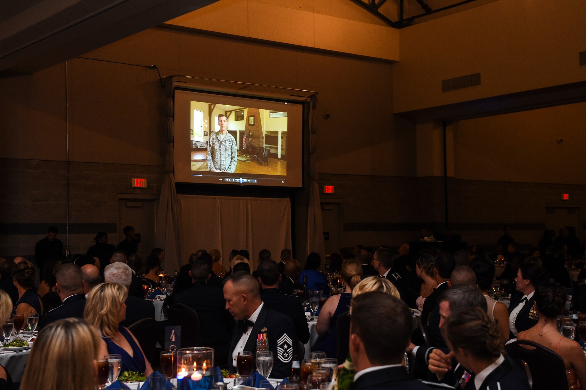 Airmen and guests watch a video during the Air Force Ball Sept. 19, 2015, in Valdosta, Ga. The video highlighted 93d Air Ground Operations Wing and Flying Tigers Airmen all over the globe ensuring the mission gets done. (U.S. Air Force photo by Senior Airman Ceaira Tinsley/Released)