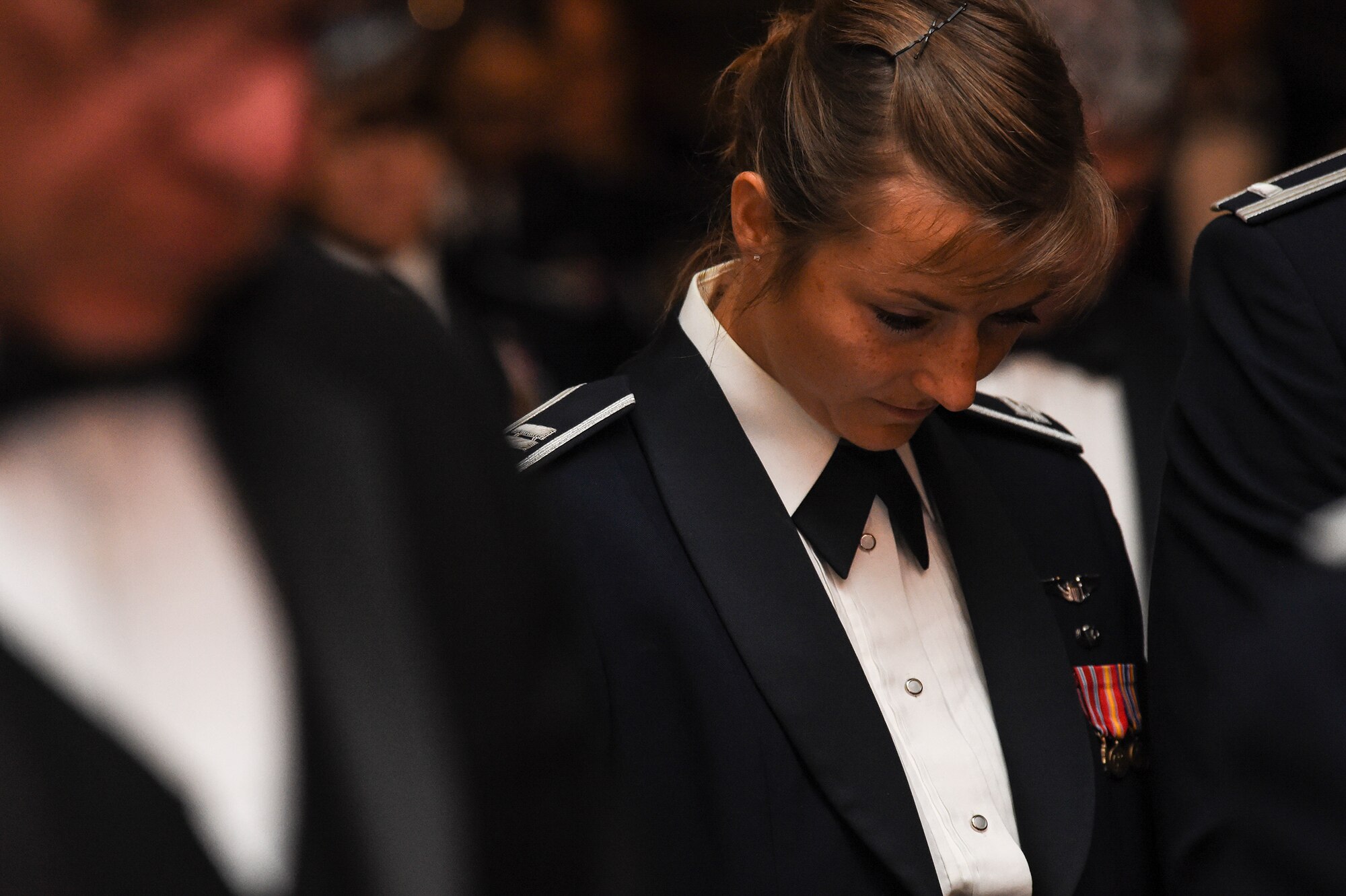 U.S. Air Force Capt. Christy Wise, 71st Rescue Squadron HC-130 pilot, bows her head in prayer during the Air Force Ball Sept. 19, 2015, in Valdosta, Ga. Wise addressed the crowd about the events that lead up to her boating accident and the road she is taking to get back in the cockpit. (U.S. Air Force photo by Senior Airman Ceaira Tinsley/Released)