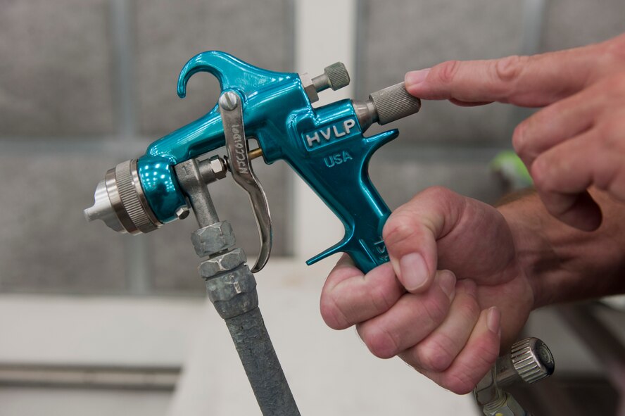 Jeff Dezell, 57th Maintenance Group Corrosion shop lead, holds a spray gun used to paint aircraft inside a temperature-controlled building on Nellis Air Force Base, Nev., Sept. 9, 2015. The corrosion shop assigns four people to work on each shift. (U.S. Air Force photo by Airman 1st Class Mikaley Kline)