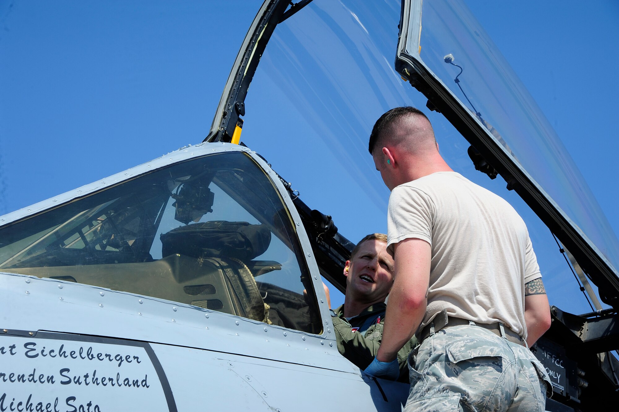 U.S. Air Force Airman 1st Class Jeff Gabriellini, 355th Aircraft Maintenance Squadron crew chief, speaks with Lt. Col. Patrick Smiley, 355th Operations Group director of staff, during aircraft recovery after Smiley landed at Nellis Air Force Base, Nev., Sept. 10, 2015. Eight A-10s from the 357th Fighter Squadron at Davis-Monthan AFB, Ariz., arrived at Nellis to participate in Green Flag-West 15-10 with seven other units. (U.S. Air Force photo by Senior Airman Betty R. Chevalier/Released)