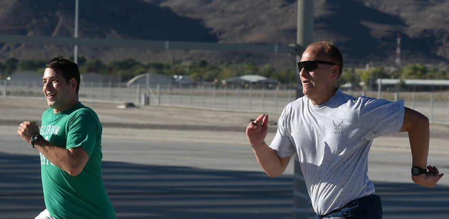 Airmen of the 432nd Wing/432nd Air Expeditionary Wing race each other to the finish line after running the 432nd Maintenance Group Golden Bolt 5K at Creech Air Force Base, Nevada, Sept. 18, 2015. Airmen ran the Creech flightline to raise awareness throughout the Wing on the effects foreign object debris (FOD) can cause to aircraft and maintenance equipment. (U.S. Air Force photo by Tech. Sgt. Nadine Barclay)  