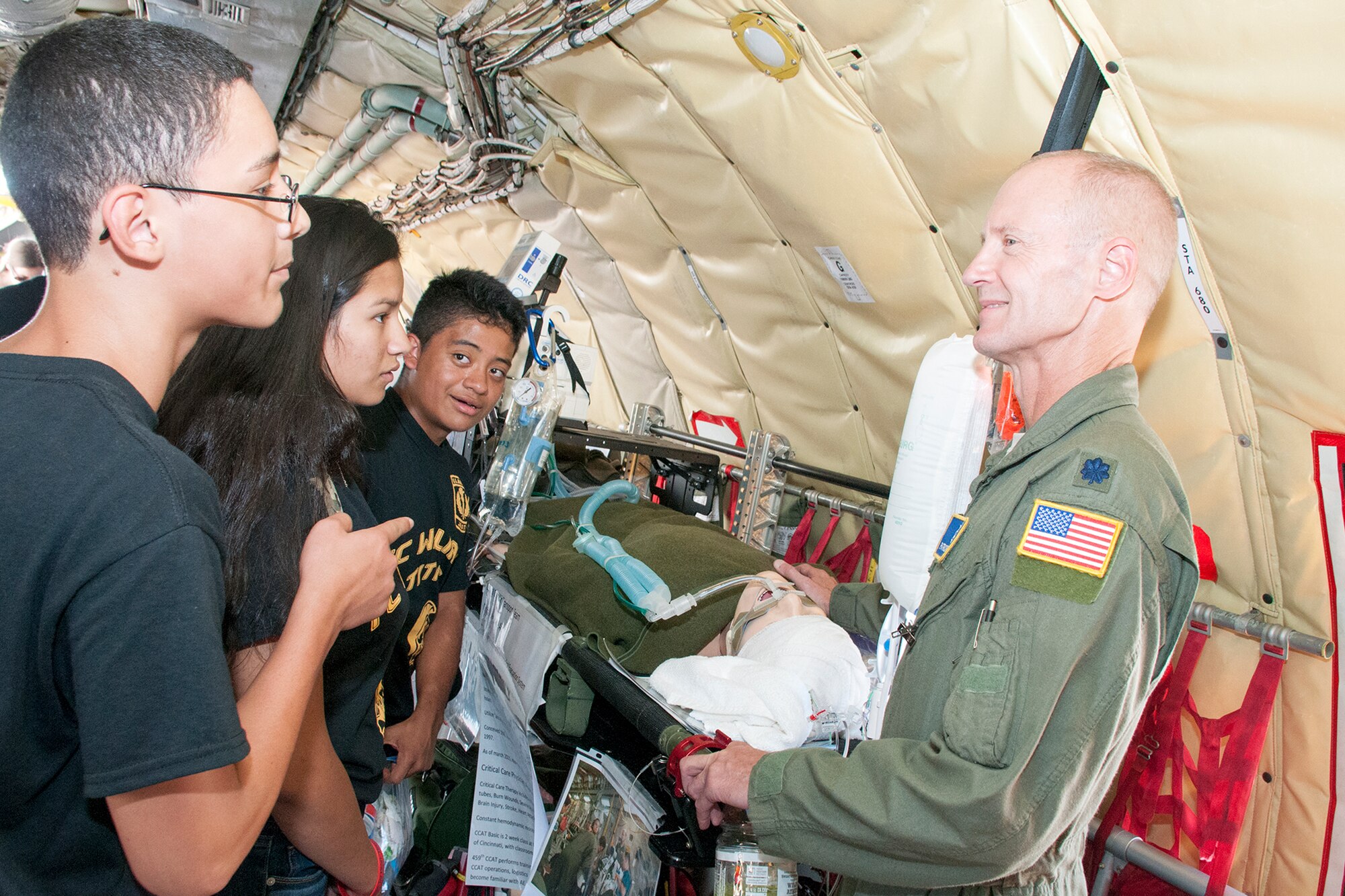 Lt. Col. Patrick Falvey, 459th Aeromedical Staging Squadron critical care transport nurse (right), discusses the inflight medical capabilities provided by the squadron to a group of T.C. Williams high school students onboard a KC-135R Stratotanker during the Andrews Air Show Sept. 18, 2015.The 459th Airlift Wing provided tours of the aircraft and illustrated medical and refueling capabilities to the public during the open house. (U.S. Air Force photo/Staff Sgt. Kat Justen)