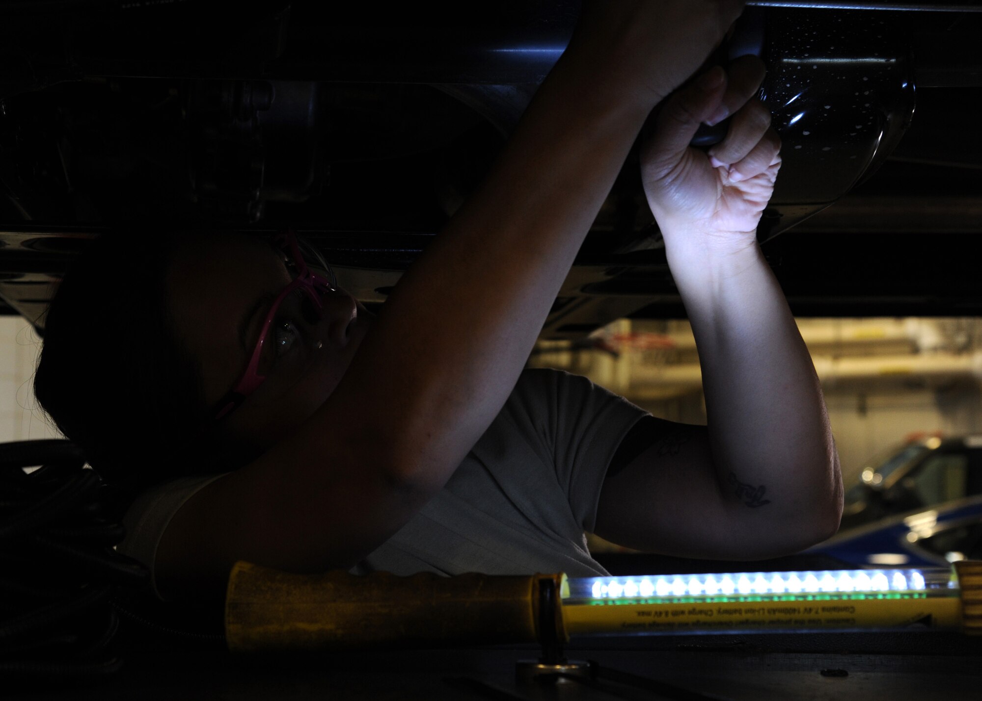 Staff Sgt. Jessica Kemmy, 319th Logistics Readiness Squadron vehicle and vehicular equipment maintenance technician, works underneath a truck Sept. 21, 2015, on Grand Forks Air Force Base, North Dakota. The 319th LRS is scheduled to provide free vehicle inspections Sept. 26, 2015, in preparation for winter. (U.S. Air Force photo by Airman 1st Class Ryan Sparks/Released)