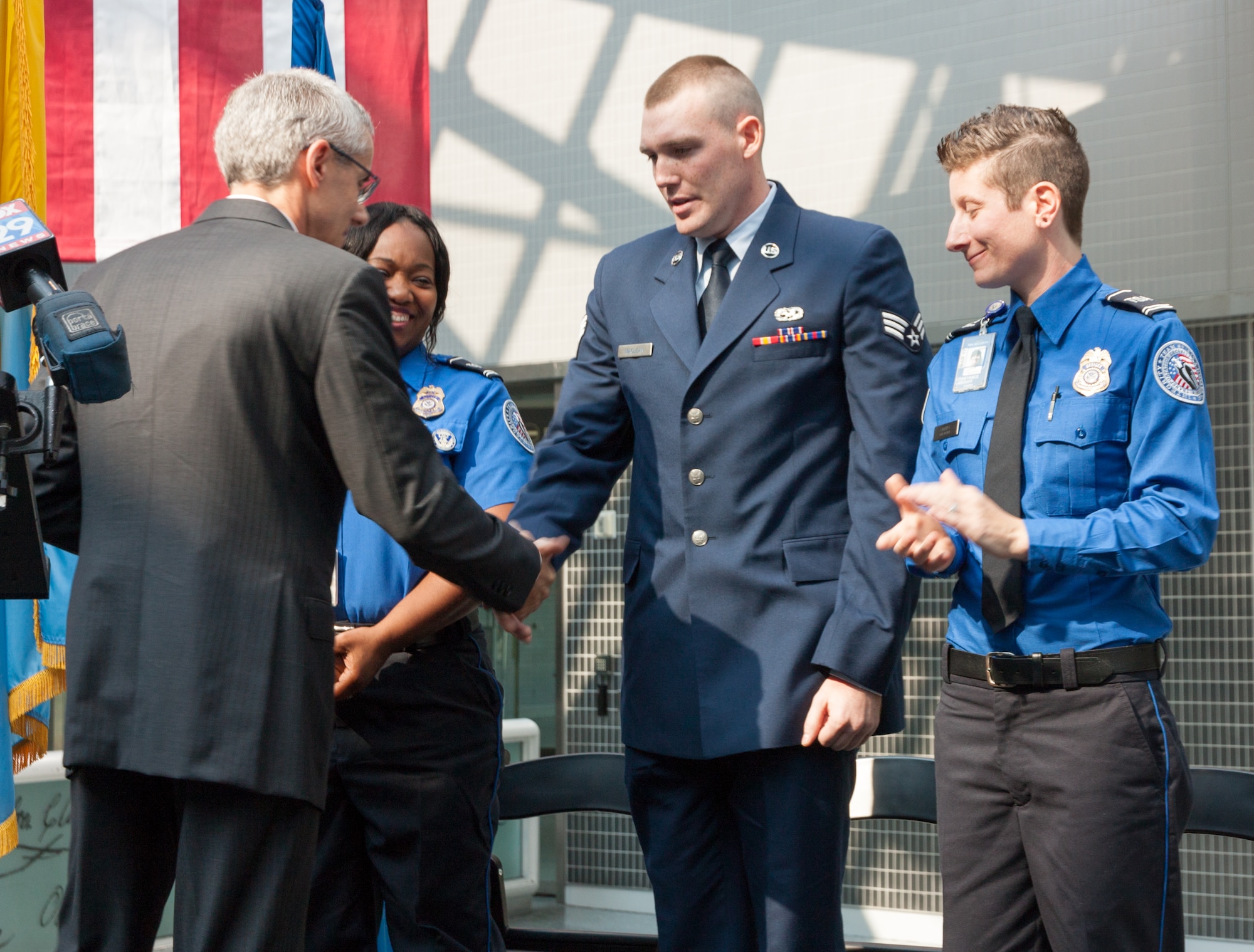Peter Neffenger, Transportation Safety Administration administrator, thanks Senior Airman Bryan MacLean, 436th Maintenance Squadron crew chief, at a ceremony Sept. 4, 2015, at the Philadelphia International Airport. On July 29, 2015, MacLean provided life-saving medical attention, CPR and automatic external defibrillator (AED), to George Senkler who suffered a heart attack while he was processing through a TSA security checkpoint. (Courtesy photo)