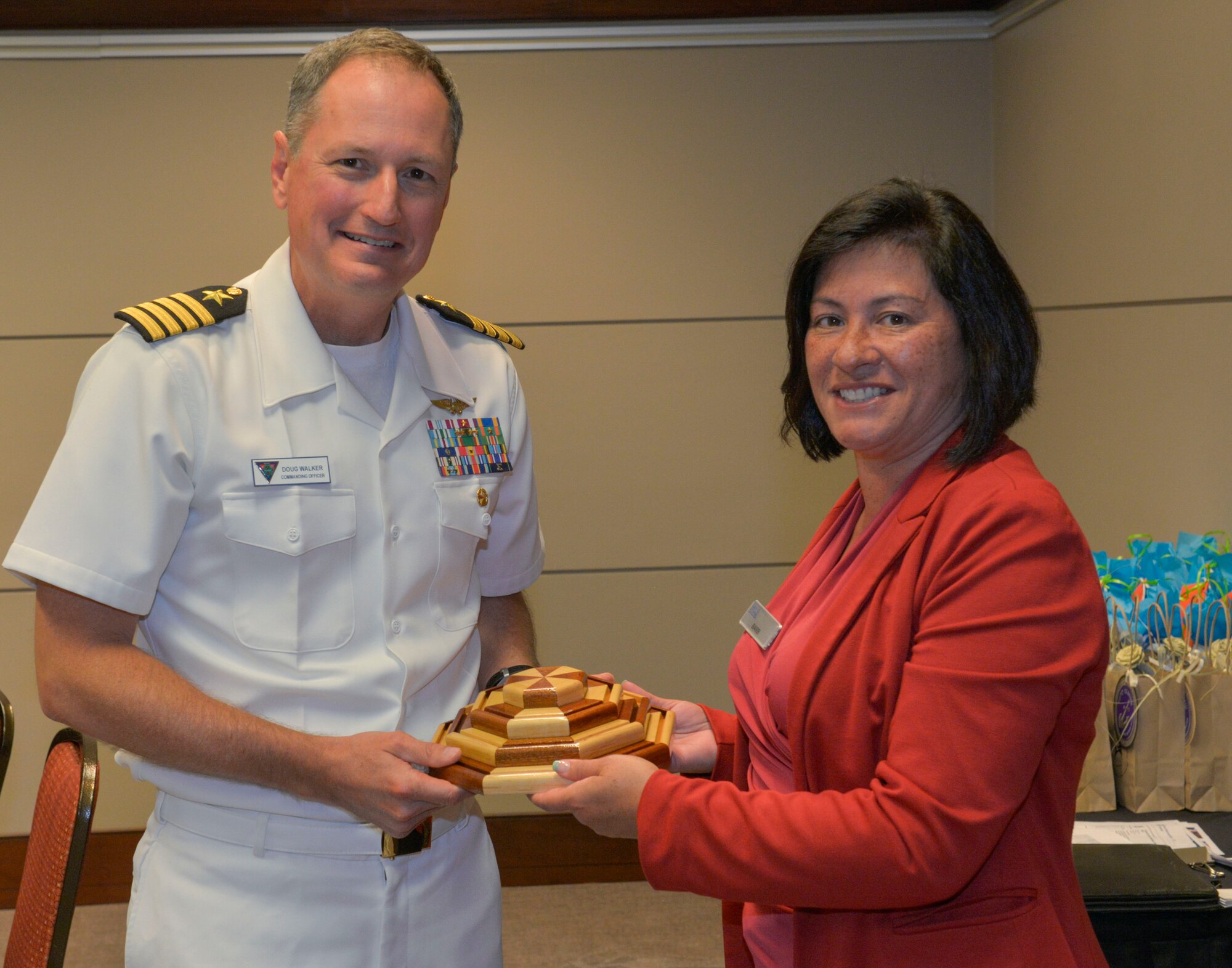 Navy Captain Doug Walker, the new Navy ROTC commanding officer and professor of naval science at the USC, Columbia, SC receives a gift from the Charleston County Navy League for his service during the Ombudsman luncheon at the Embassy Suites Convention Center in Charleston, SC, Sept. 17, 2015. Walker assumes command of the ROTC unit this week. (U.S. Air Force photo/Airman 1st Class Thomas T. Charlton)