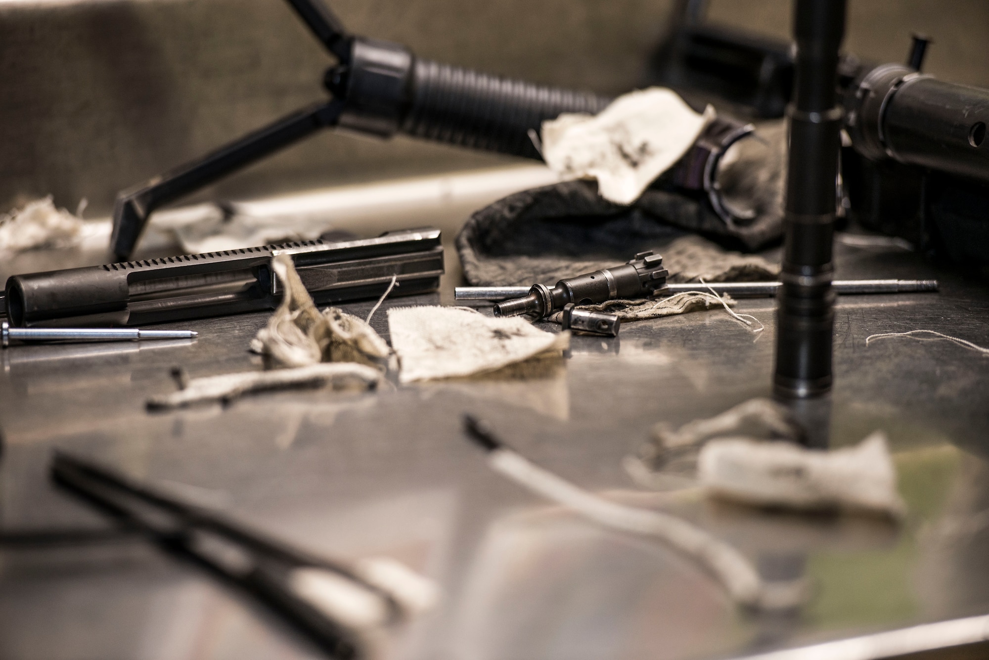 Pieces of a disassembled M4 carbine and cleaning supplies sit on a counter at the 5th Security Forces Armory at Minot Air Force Base, N.D., September 18, 2015. Airmen use CLP – a cleaning chemical, brushes, and cloth wipes to remove carbon fouling cause by firing their weapons.  (U.S. Air Force photo/ Airman 1st Class Justin T. Armstrong)