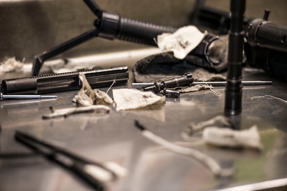 Pieces of a disassembled M4 carbine and cleaning supplies sit on a counter at the 5th Security Forces Armory at Minot Air Force Base, N.D., September 18, 2015. Airmen use CLP – a cleaning chemical, brushes, and cloth wipes to remove carbon fouling cause by firing their weapons.  (U.S. Air Force photo/ Airman 1st Class Justin T. Armstrong)
