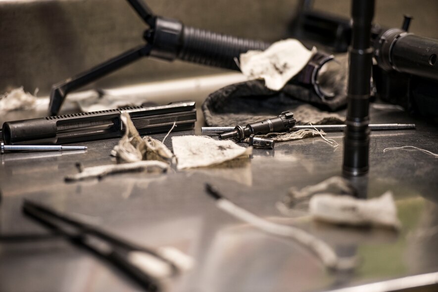 Pieces of a disassembled M4 carbine and cleaning supplies sit on a counter at the 5th Security Forces Armory at Minot Air Force Base, N.D., September 18, 2015. Airmen use CLP – a cleaning chemical, brushes, and cloth wipes to remove carbon fouling cause by firing their weapons.  (U.S. Air Force photo/ Airman 1st Class Justin T. Armstrong)