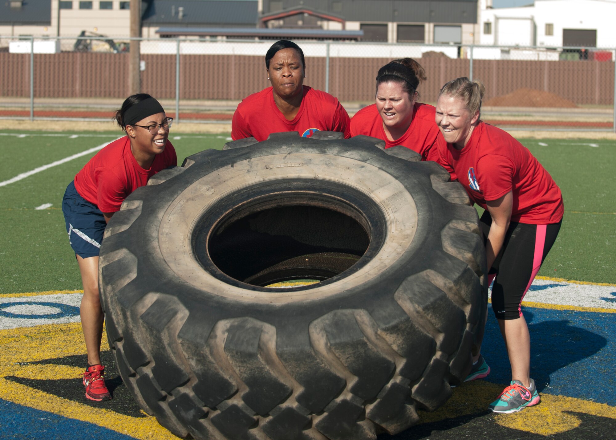 U.S. Air Force Airmen from the 7th Medical Group flip a tire Aug. 26, 2015, at Dyess Air Force Base, Texas. One event at the Dyess Warrior Week was a relay race with a kettlebell carry, tire flip and a buddy carry. The event was created as a way for Dyess to strengthen comradery in different squadrons through competition. (U.S. Air Force photo by Airman Quay Drawdy/Released)