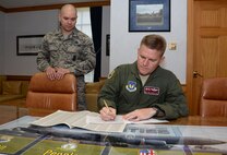 U.S. Air Force Col. Thomas D. Torkelson, right, 100th Air Refueling Wing commander, signs a Combined Federal Campaign donation form in his office with U.S. Air Force Master Sgt. Christopher Carrier, 100th Security Forces Squadron NCO in charge of operations support, Sept. 21, 2015, on RAF Mildenhall, England. The campaign is an annual fundraiser which gives federal employees the opportunity to donate to any of the nonprofit charity organizations registered to the CFC. (U.S. Air Force photo by Gina Randall/Released)