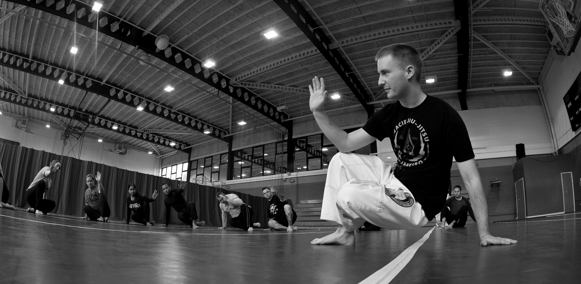 U.S. Air Force Staff Sgt. Matthew McConnell, 83rd Network Operations Squadron Detachment 4 plans and integration NCO and deputy director of Kaiserslautern Military Community Gracie Defense System, Ramstein Air Base, Germany, demonstrates how to stand up into a defensive position during a self-defense class Sept. 15, 2015, at the Northside Fitness Center on RAF Mildenhall, England. Every time the students rose from a seated position they had to get into a defensive position to help them practice the technique. (U.S. Air Force photo by Staff Sgt. Micaiah Anthony/Released)  