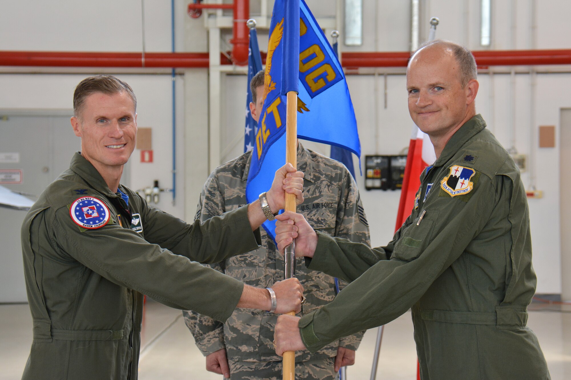 U.S. Air Force Col. Michael Thompson, 52nd Operations Group commander, left, hands the ceremonial guidon to Lt. Col. Jason Repak, incoming commander of Detachment 1, 52nd OG, during a change of command ceremony at Lask Air Base, Poland, Sept. 18, 2015. Repak assumed command of the detachment from U.S. Air Force Lt. Col. Jack Harman. (U.S. Air Force photo by Master Sgt. Paul Gorman/Released)