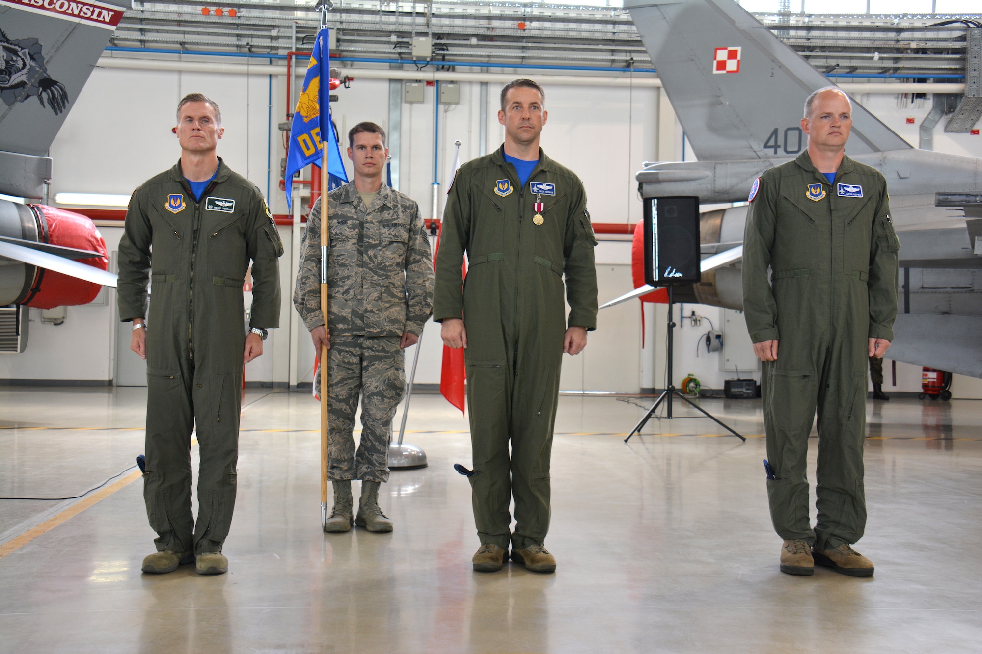 U.S. Air Force Col. Michael Thompson, 52nd Operations Group commander, left, Lt. Col. Jack Harman, outgoing 52nd OG, Detachment 1, commander, center, and Lt. Col. Jason Repak, incoming commander of Detachment 1, 52nd OG, right, stand at parade rest during a change of command ceremony at Lask Air Base, Poland, Sept. 18, 2015. Repak assumed command of the detachment from Harman. (U.S. Air Force photo by Master Sgt. Paul Gorman/Released)