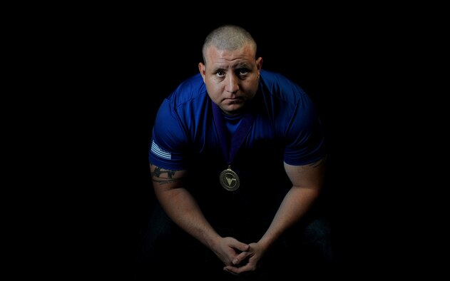 Tech. Sgt. David Hernandez, 509th Logistics Readiness Squadron resource advisor assistant, wears his gold medal Sept. 9, 2015, at Whiteman Air Force Base, Mo. He earned first place in a power lifting event at a competition with other wounded warriors. (U.S. Air Force photo illustration by Airman 1st Class Michaela R. Slanchik/Released)